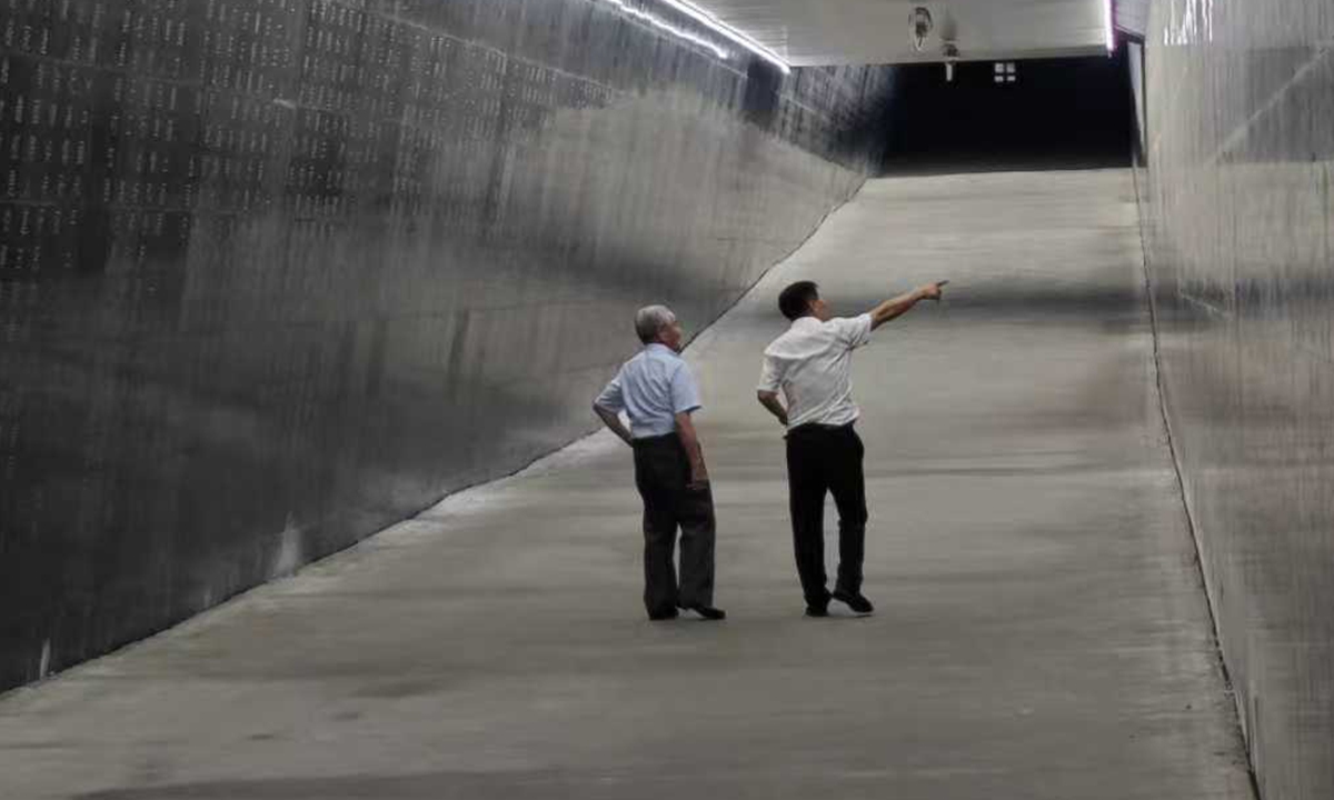 Jin Chengmin (right) and Shimizu Hideo walk past the testimony wall etched with confessions from former Unit 731 members and victims' oral accounts at the Unit 731's former site in Harbin on March 13, 2024.