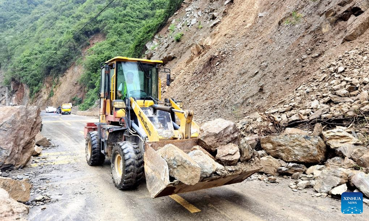 A staff member of the transportation department drives a loader to move rocks on a road in Baokang County, Xiangyang City, central China's Hubei Province, Aug. 10, 2025. Recently, affected by continuous heavy rainfall, many roads in Baokang County were blocked. The transportation department quickly carried out rescue and resumed the weather-disrupted traffic. (Photo by Chen Quanlin/Xinhua)