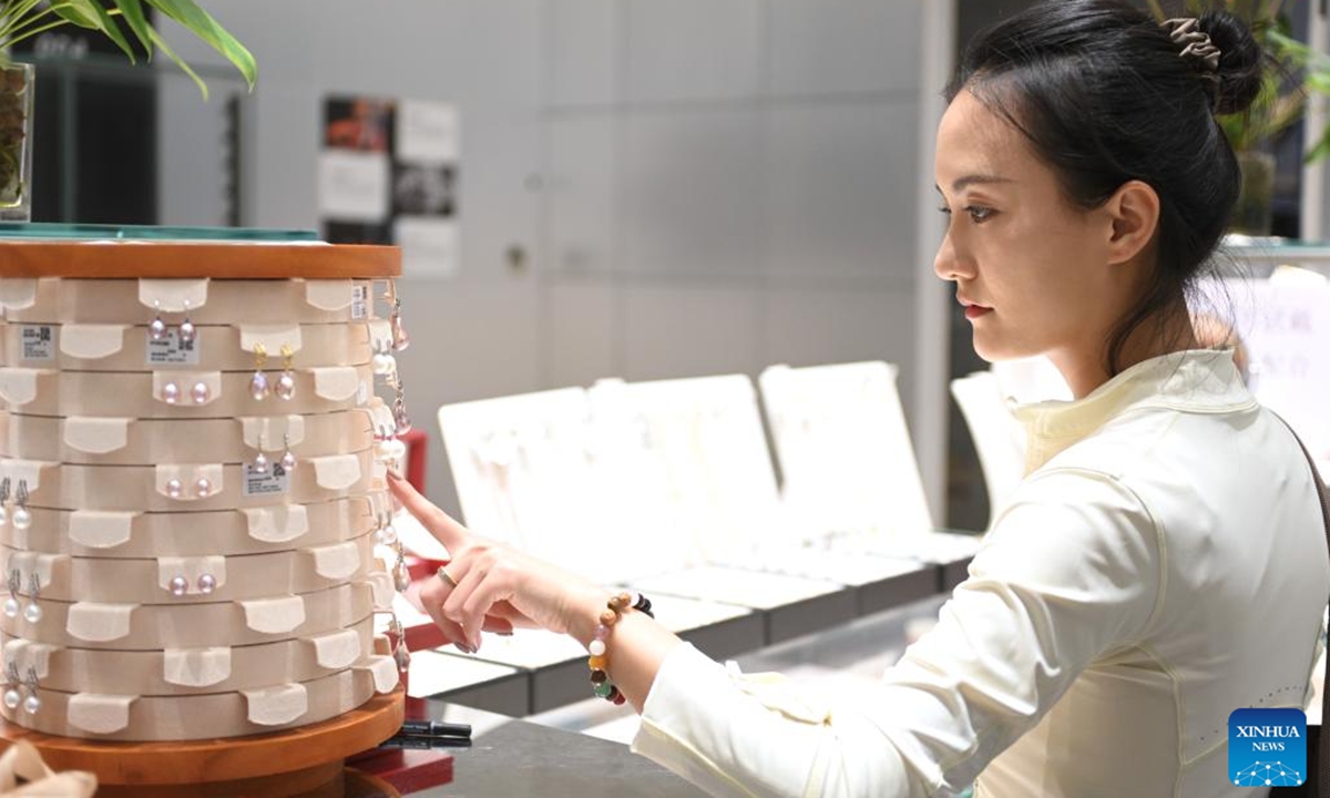 A customer selects pearl earrings at a trading center for jewelry products in Shanxiahu Town, Zhuji City of east China's Zhejiang Province, Aug. 9, 2025. Shanxiahu Town of Zhejiang Province is renowned for its pearl industry that ranges from pearl farming, processing, trading to cultural tourism. (Xinhua/Mao Zhu)