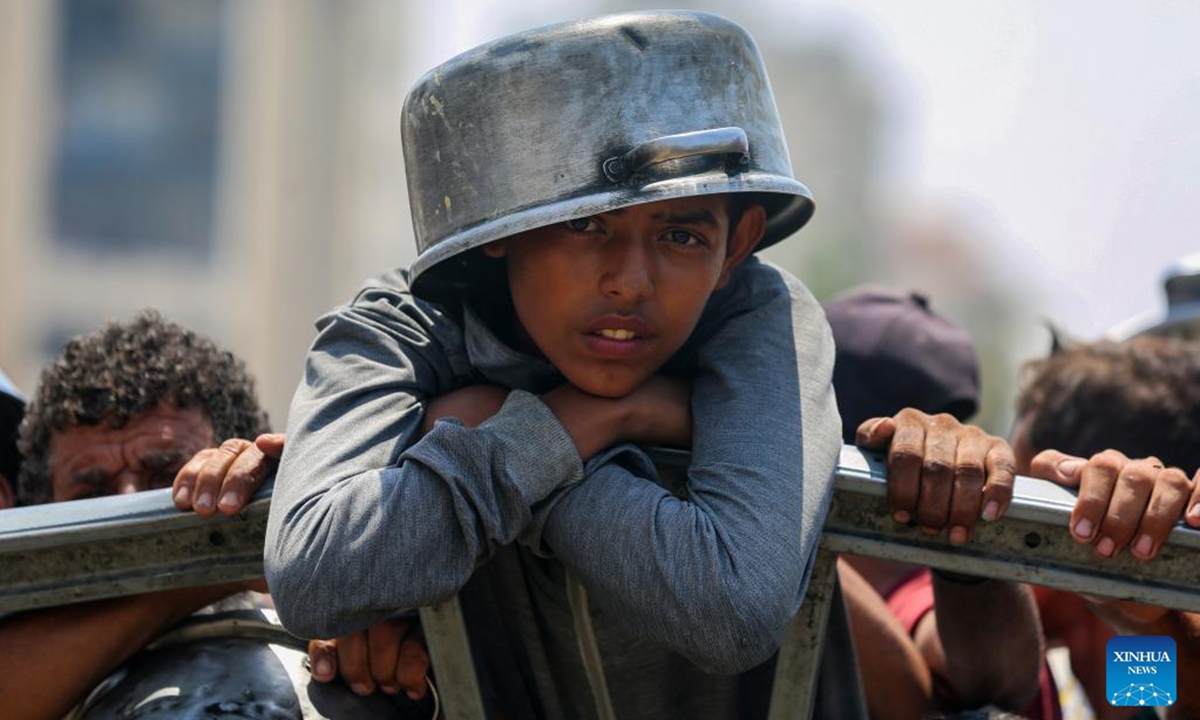 Displaced Palestinians wait to get free food in the west of Gaza City, on Aug. 10, 2025. (Photo by Rizek Abdeljawad/Xinhua)