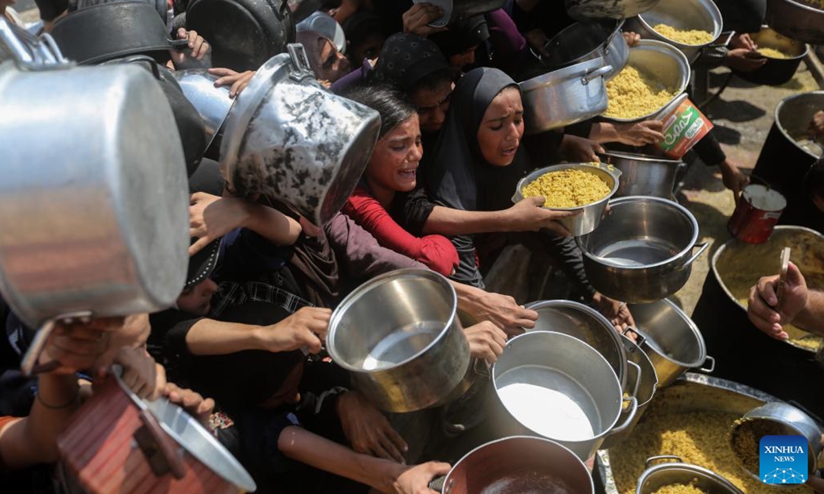 Displaced Palestinians wait to get free food in the west of Gaza City, on Aug. 10, 2025. (Photo by Rizek Abdeljawad/Xinhua)