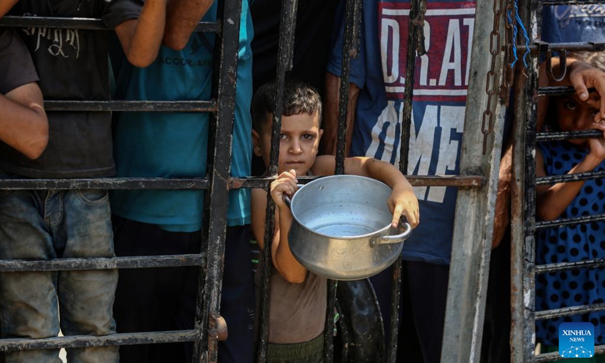 Displaced Palestinians wait to get free food in the west of Gaza City, on Aug. 10, 2025. (Photo by Rizek Abdeljawad/Xinhua)