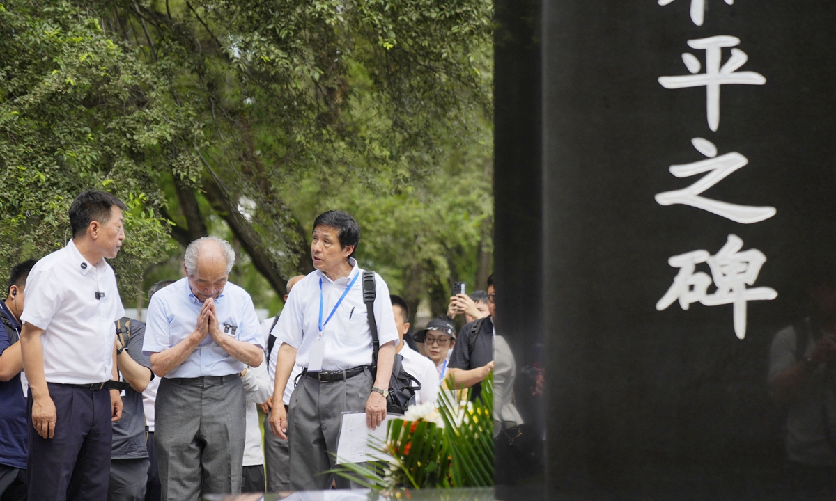 Jin Chengmin (left) and Shimizu Hideo (center) stand in front of the 