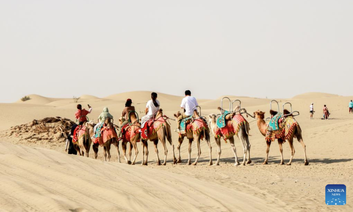 Tourists ride camels at the desert gate scenic area in Alaer, northwest China's Xinjiang Uygur Autonomous Region, Aug. 12, 2025. The desert gate scenic area, covering an area of 14 hectares, receives an average of 600,000 visits annually. (Xinhua/Liu Jiaqi)