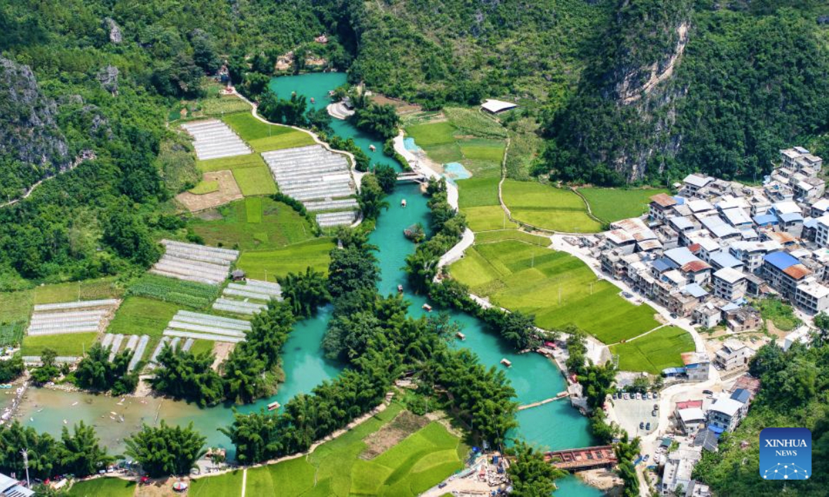 An aerial drone photo taken on Aug. 12, 2025 shows tourists taking boat tours at the Daxiaojing scenic spot in Luodian County, southwest China's Guizhou Province. Luodian County in recent years has continuously upgraded its infrastructure and optimized its tourism service system, transforming its abundant mountain and water resources into tourist attractions. (Xinhua/Tao Liang)