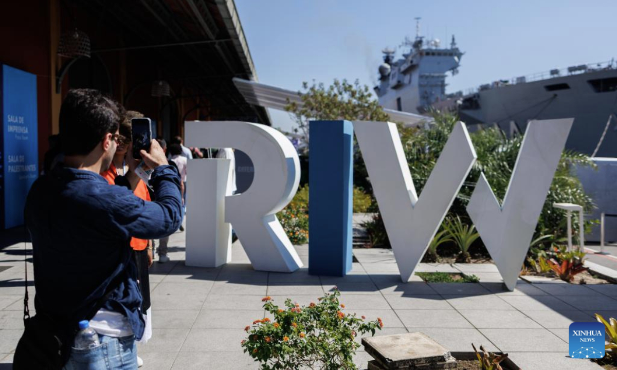 A visitor takes photos in front of the sign of the Rio Innovation Week in Rio de Janeiro, Brazil, on Aug. 13, 2025. (Photo by Claudia Martini/Xinhua)