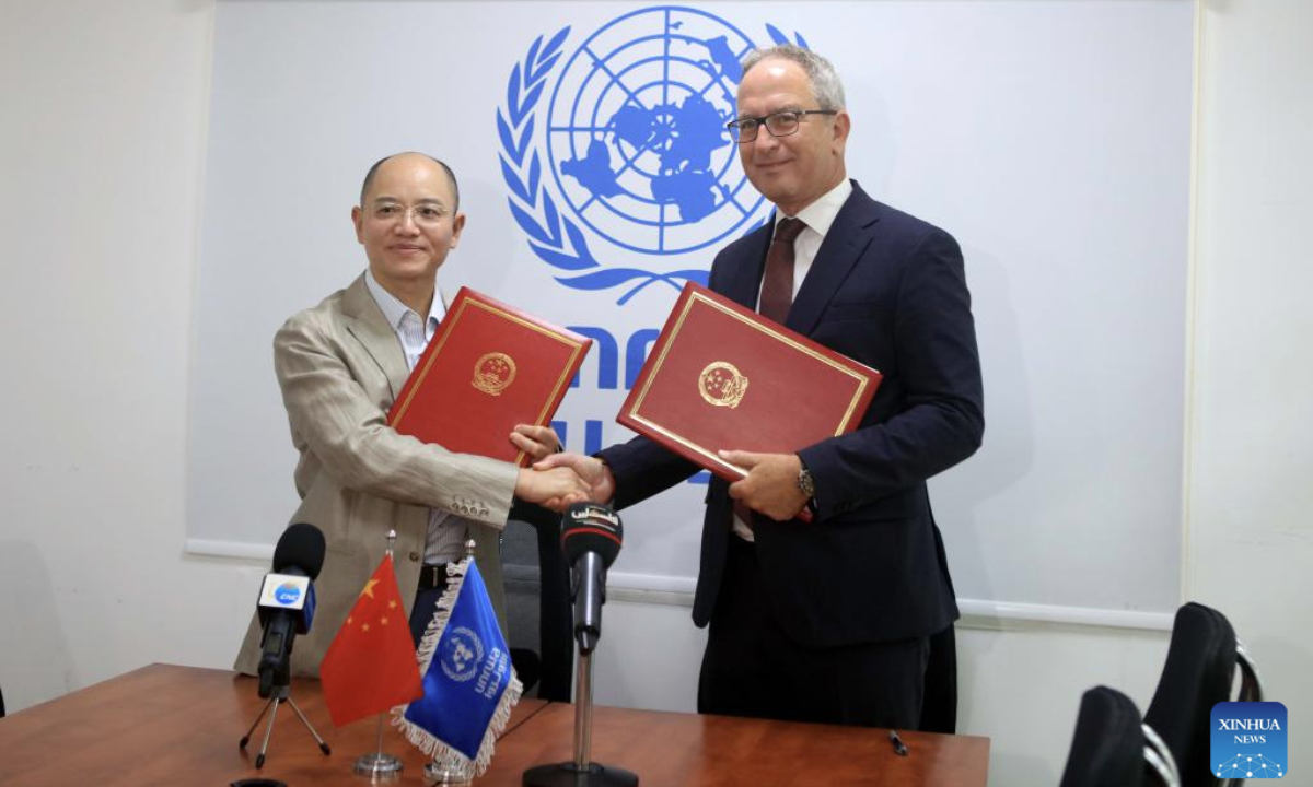 Zeng Jixin (L), head of China's office to the State of Palestine, shakes hands with Karim Amer, director of partnerships of the United Nations Relief and Works Agency for Palestine Refugees in the Near East (UNRWA), after signing a contribution agreement in Amman, Jordan, Aug. 13, 2025. (Photo by Mohammad Abu Ghosh/Xinhua)