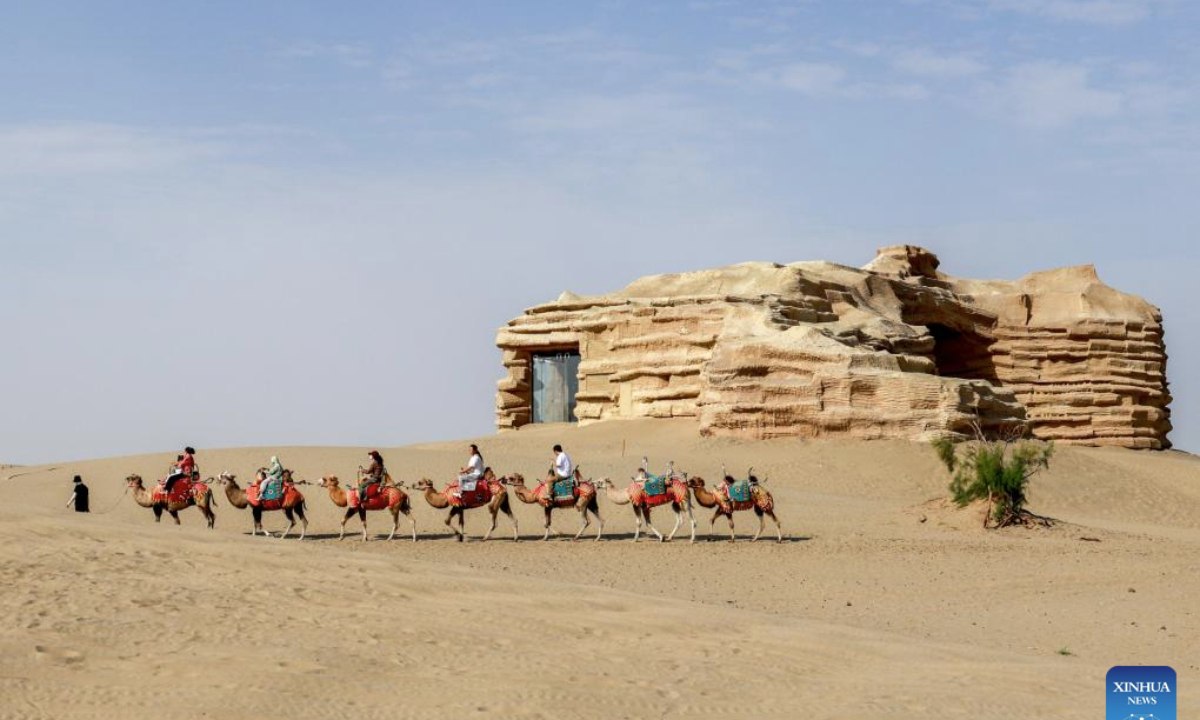 Tourists ride camels at the desert gate scenic area in Alaer, northwest China's Xinjiang Uygur Autonomous Region, Aug. 12, 2025. The desert gate scenic area, covering an area of 14 hectares, receives an average of 600,000 visits annually. (Xinhua/Liu Jiaqi)