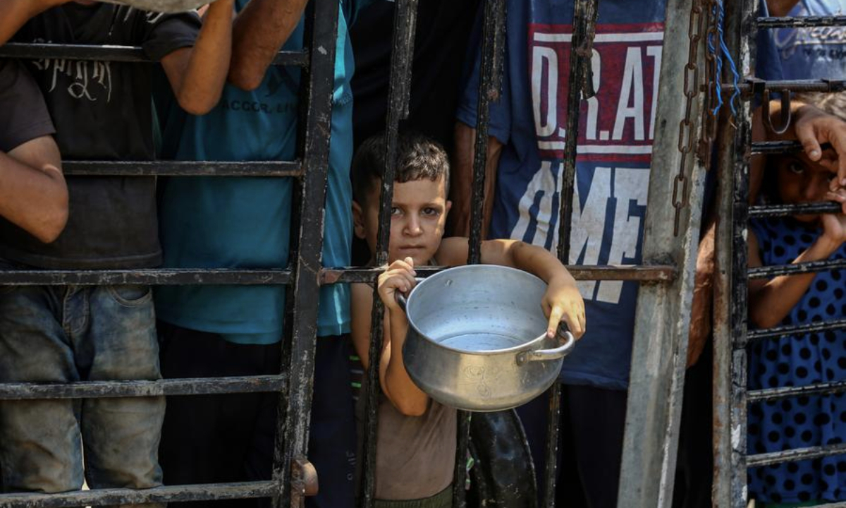 Displaced Palestinians wait to get free food in the west of Gaza City, on Aug. 10, 2025. (Photo by Rizek Abdeljawad/Xinhua)