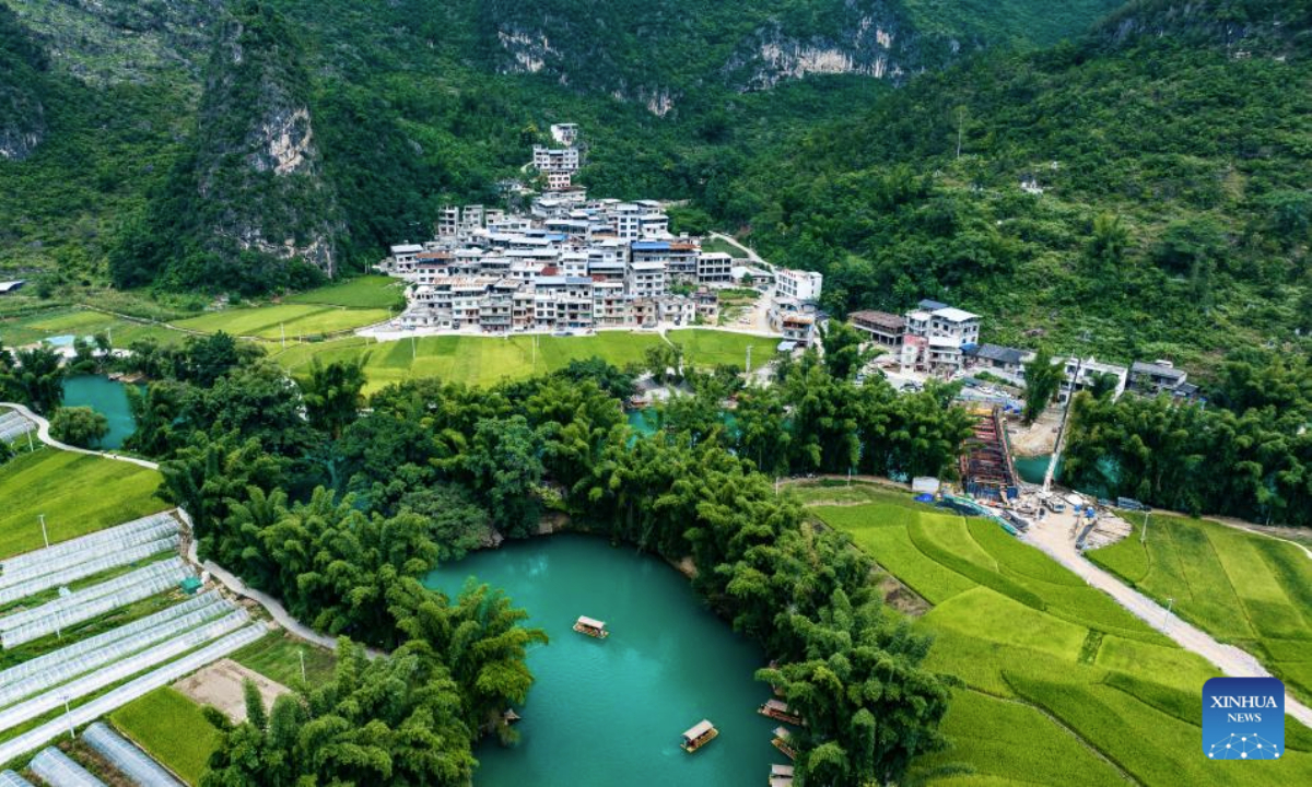 An aerial drone photo taken on Aug. 12, 2025 shows tourists taking boat tours at the Daxiaojing scenic spot in Luodian County, southwest China's Guizhou Province. Luodian County in recent years has continuously upgraded its infrastructure and optimized its tourism service system, transforming its abundant mountain and water resources into tourist attractions. (Xinhua/Tao Liang)
