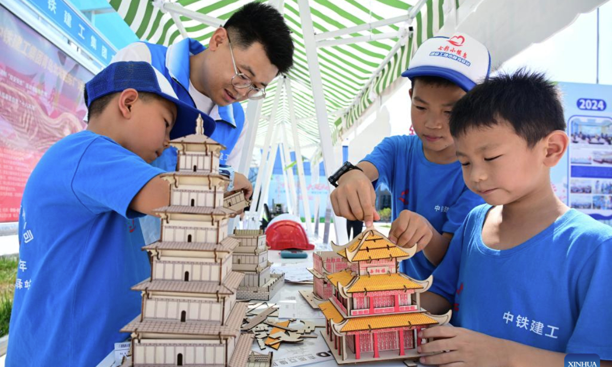 Children assemble architectural models in Qingdao, east China's Shandong Province, Aug. 12, 2025. Children across China take part in various kinds of activities to spend their summer holiday. (Xinhua/Li Ziheng)