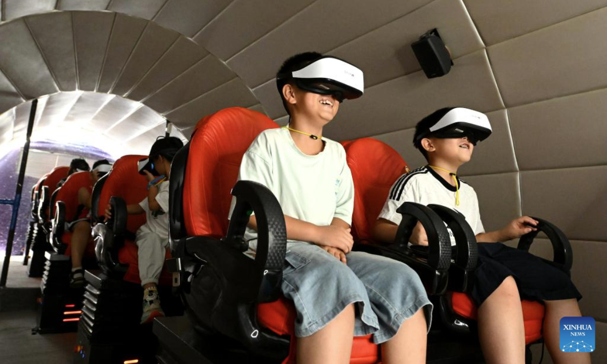 Children experience simulation inside a mock space capsule in Shijiazhuang, north China's Hebei Province, Aug. 12, 2025. Children across China take part in various kinds of activities to spend their summer holiday. (Photo by Chen Qibao/Xinhua)