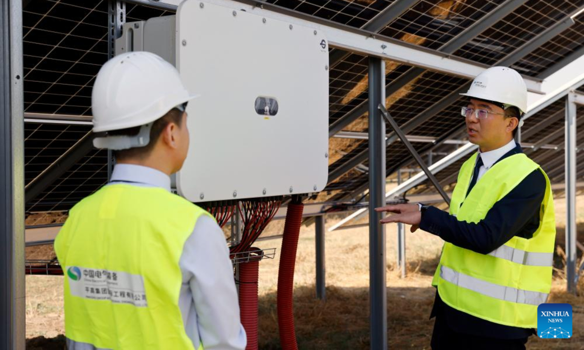 Zhu Jibin (R), general manager of Pinggao Group International Engineering Co., Ltd., communicates with a colleague at a 31.82-megawatt photovoltaic power station in Stefan cel Mare, Calarasi County, Romania, Aug. 12, 2025. (Photo by Cristian Cristel/Xinhua)