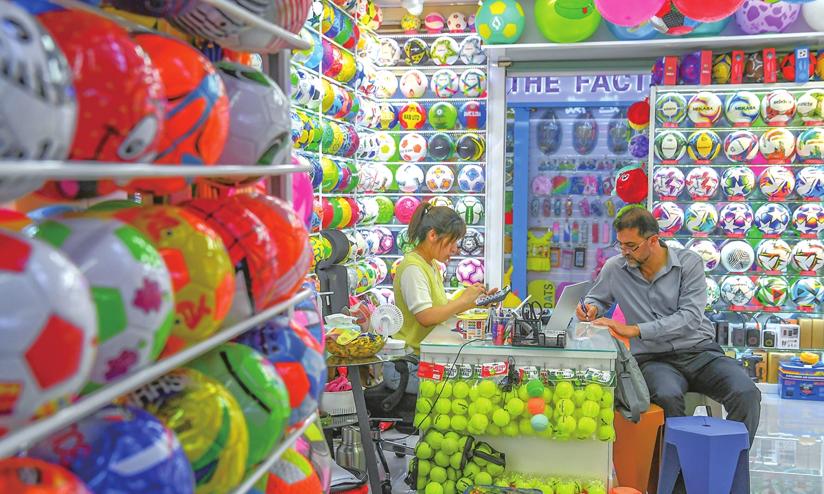 A foreign client negotiates purchases of sports balls at a shop in the Yiwu International Trade City, East China's Zhejiang Province, on August 12, 2025. Renowned as the 