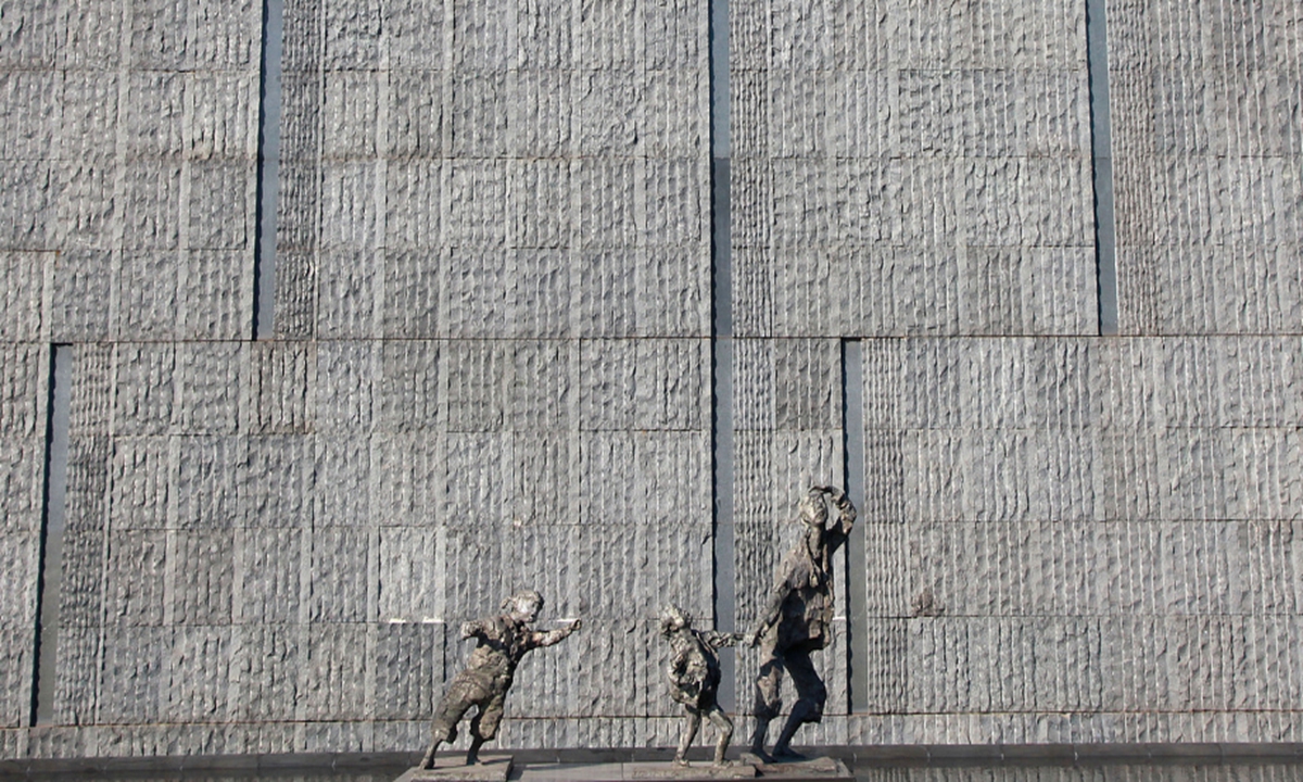A sculpture depicting the historical reality of the Nanjing Massacre shows an elderly man fleeing Japanese aerial bombardment while carrying orphans who have lost both parents, located at the Memorial Hall of the Victims in Nanjing Massacre by Japanese Invaders in Nanjing, Jiangsu Province. Photo: VCG