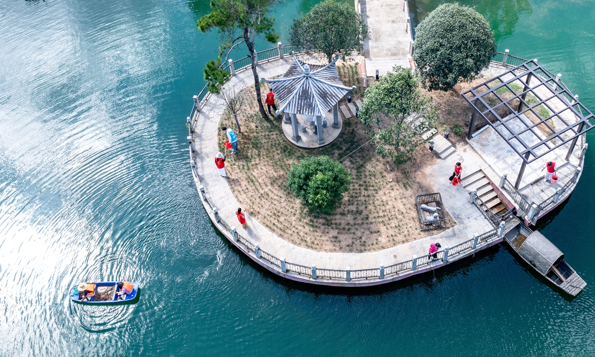 Volunteers remove floating debris to beautify the riverbank in a village in Changxing County, Huzhou, East China's Zhejiang Province, August 14, 2025. Photo: VCG