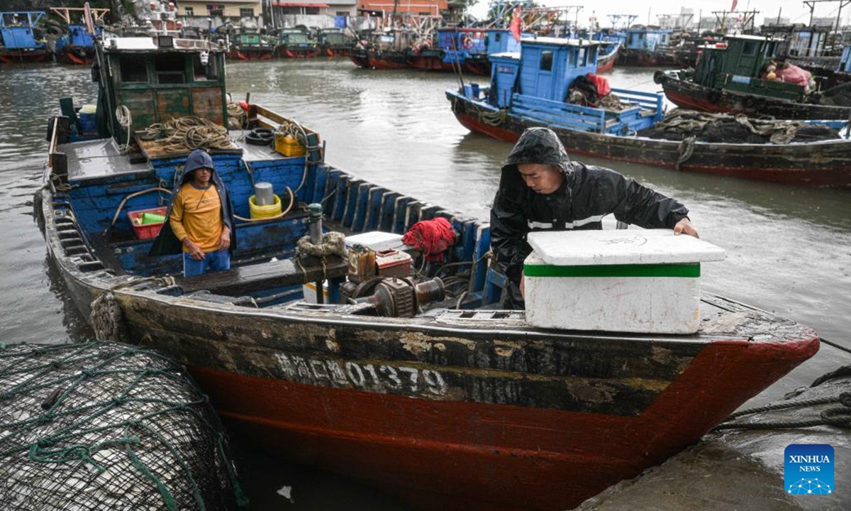 Fishermen transfer supplies on a fishing vessel which is temporarily delayed from setting sail due to tropical depression at a port in Haikou, south China's Hainan Province, Aug. 16, 2025. The three-and-a-half-month summer fishing moratorium in the South China Sea concluded at noon on Saturday. To ensure safety amid an ongoing tropical depression, the Hainan Provincial Department of Agriculture and Rural Affairs issued a notice urging fishermen to temporarily suspend fishing activities and to keep their vessels safely sheltered in port. (Xinhua/Pu Xiaoxu)