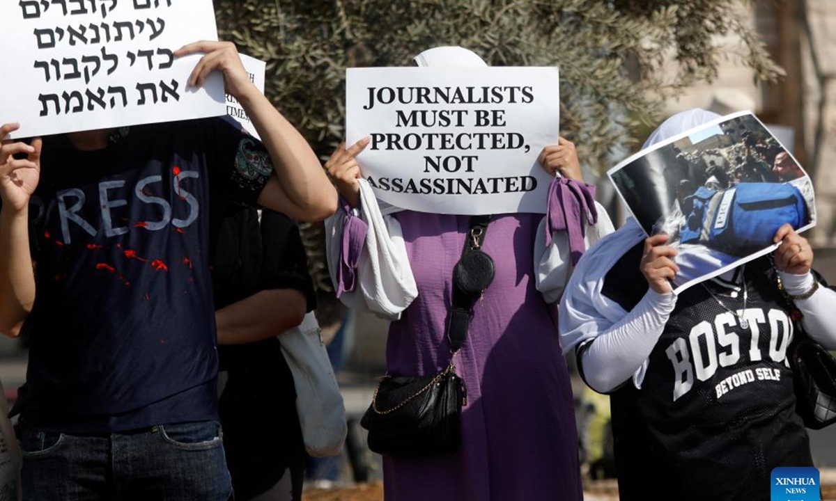 Palestinian and Israeli people hold placards and photos during a protest against Israeli army's killing of journalists, in the city of Beit Jala near Bethlehem, in southern West Bank, on Aug. 15, 2025. The United Nations (UN) on Monday condemned the killing of six Palestinian journalists in Sunday's Israeli airstrike on Gaza City as a grave breach of international humanitarian law. (Photo by Mamoun Wazwaz/Xinhua)