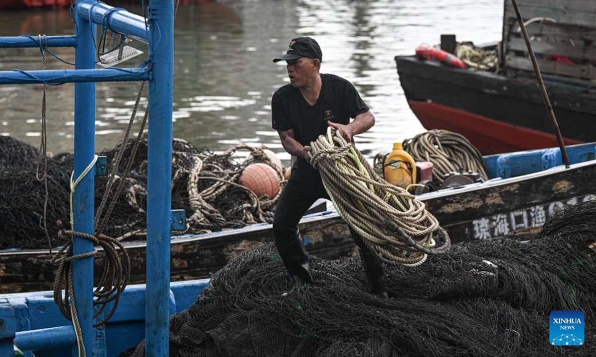 A fisherman transfers supplies on a fishing vessel which is temporarily delayed from setting sail due to tropical depression at a port in Haikou, south China's Hainan Province, Aug. 16, 2025. The three-and-a-half-month summer fishing moratorium in the South China Sea concluded at noon on Saturday. To ensure safety amid an ongoing tropical depression, the Hainan Provincial Department of Agriculture and Rural Affairs issued a notice urging fishermen to temporarily suspend fishing activities and to keep their vessels safely sheltered in port. (Xinhua/Pu Xiaoxu)