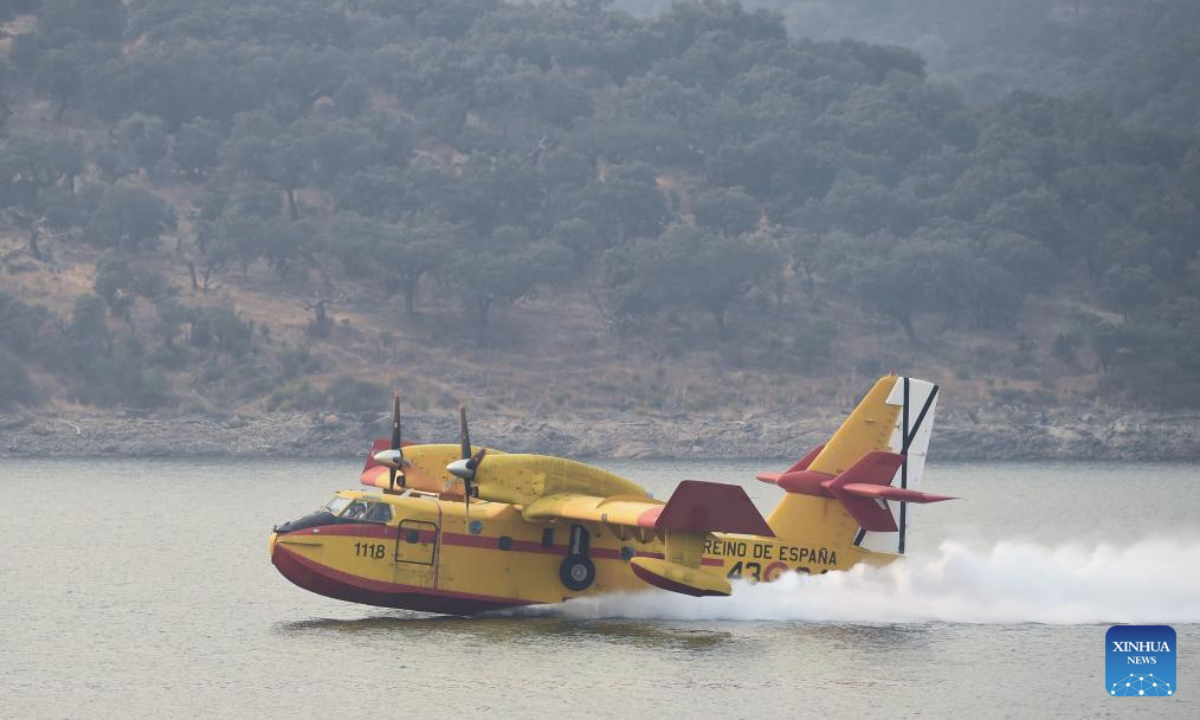 A firefighting aircraft gathers water to extinguish wildfires in Caceres, Spain, Aug. 18, 2025. The European Forest Fire Information System (EFFIS) reported on Monday that more than 343,000 hectares of land have burned in Spain so far in 2025, hitting a record high. (Photo by Gustavo Valiente/Xinhua)