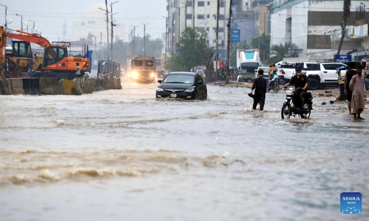 Vehicles run through a flooded street after heavy monsoon rain in Karachi, Pakistan, on Aug. 19, 2025. (Str/Xinhua)
