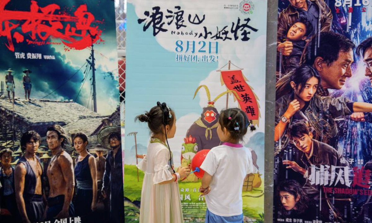Children look at film posters at a cinema in Nanjing, east China's Jiangsu Province, Aug. 17, 2025. (Photo by Du Yi/Xinhua)