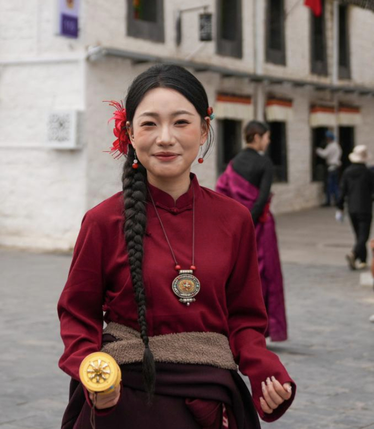 A tourist wearing Tibetan costumes poses for photos at the ancient city of Lhasa, southwest China's Xizang Autonomous Region, Aug. 19, 2025. (Xinhua/Jigme Dorje)