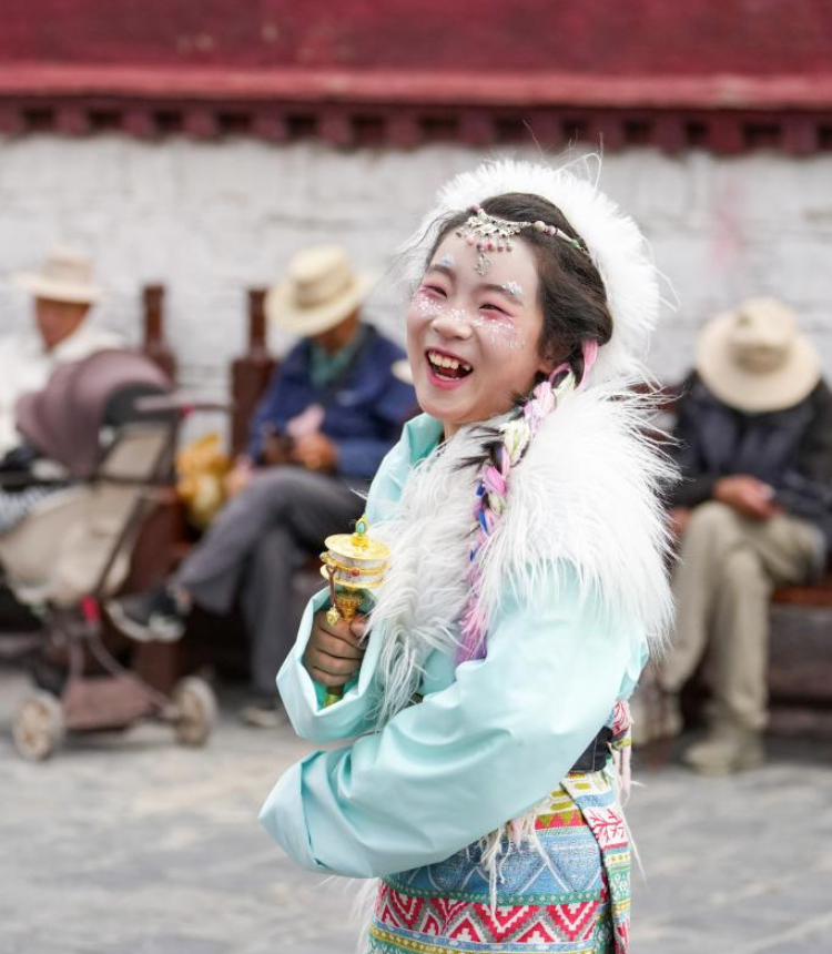 A tourist wearing Tibetan costumes poses for photos at the ancient city of Lhasa, southwest China's Xizang Autonomous Region, Aug. 19, 2025. (Xinhua/Jigme Dorje)