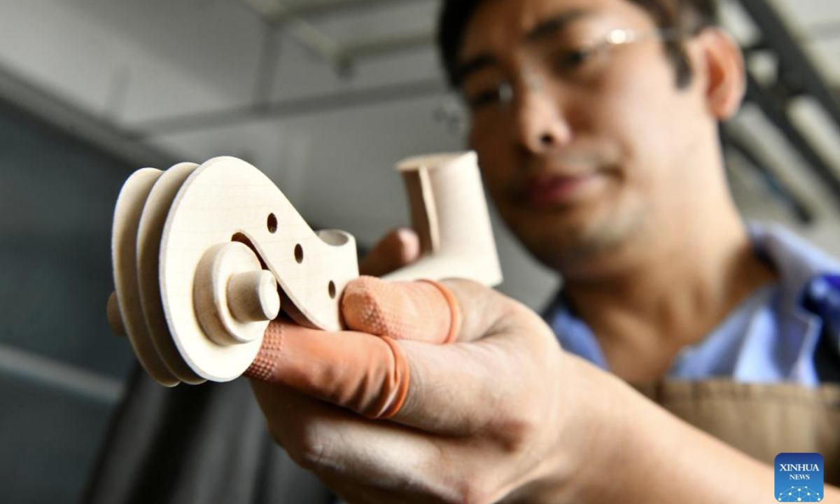 A worker makes a violin at a factory in Suning County, north China's Hebei Province, Aug. 19, 2025. Suning County in Hebei Province is now home to over 300 musical instruments enterprises, providing jobs for over 15,000 people and producing more than 1 million instruments annually in over 200 varieties. (Xinhua/Mu Yu)