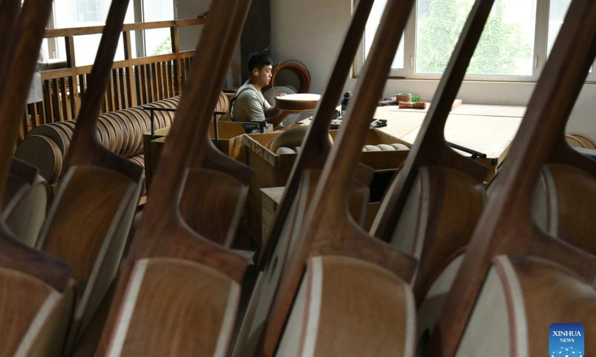A worker makes a traditional Chinese musical instrument at a factory in Suning County, north China's Hebei Province, Aug. 19, 2025. Suning County in Hebei Province is now home to over 300 musical instruments enterprises, providing jobs for over 15,000 people and producing more than 1 million instruments annually in over 200 varieties. (Xinhua/Mu Yu)