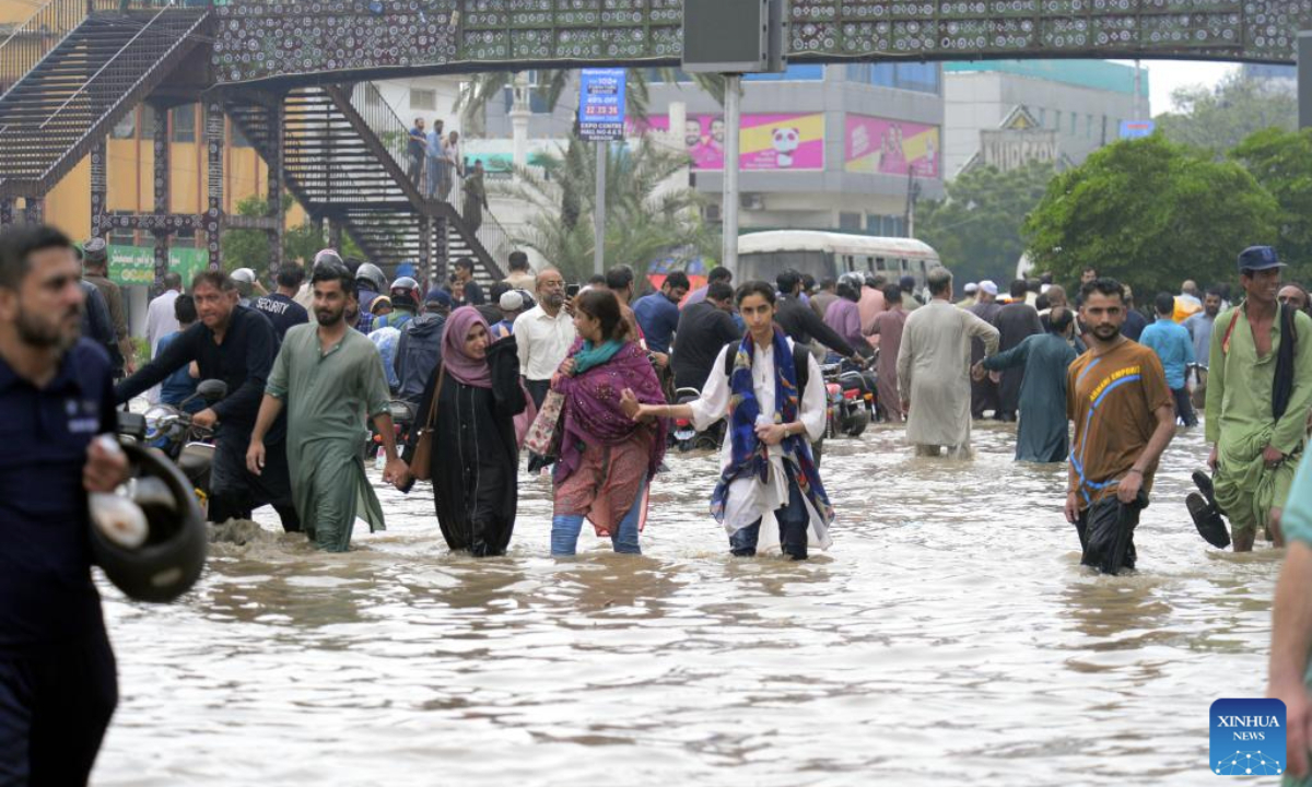 People wade through a flooded street after heavy monsoon rain in Karachi, Pakistan, on Aug. 19, 2025. (Str/Xinhua)