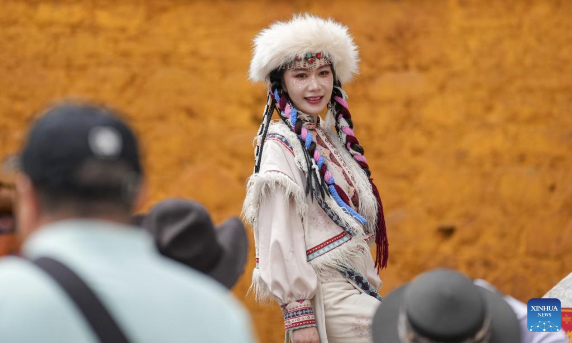 A tourist wearing Tibetan costumes poses for photos at the ancient city of Lhasa, southwest China's Xizang Autonomous Region, Aug. 19, 2025. (Xinhua/Jigme Dorje)