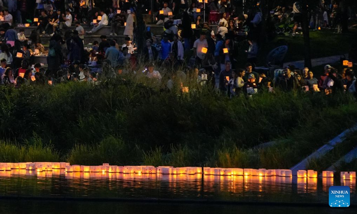 People participate in the Water Lantern Festival at Lafarge Lake in Coquitlam, British Columbia, Canada, Aug. 16, 2025. The event attracted hundreds of residents and visitors to enjoy the illuminated lanterns and share wishes for hope and joy. (Photo by Liang Sen/Xinhua)