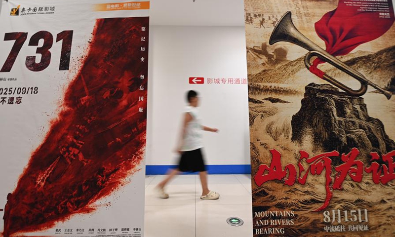 A spectator walks past movie posters at a cinema in Qingzhou, east China's Shandong Province, Aug. 17, 2025. (Photo by Wang Jilin/Xinhua)