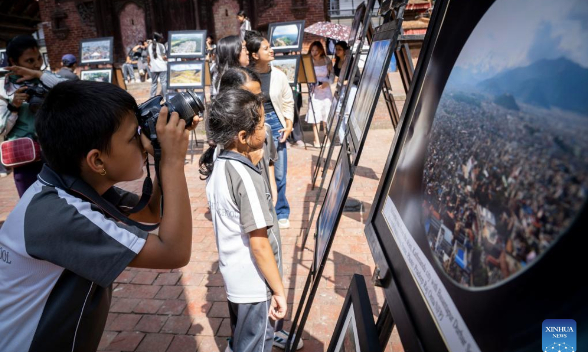 Students visit and take photos at a photo exhibition held to mark the World Photography Day in Kathmandu, Nepal, Aug. 19, 2025. (Photo by Hari Maharjan/Xinhua)