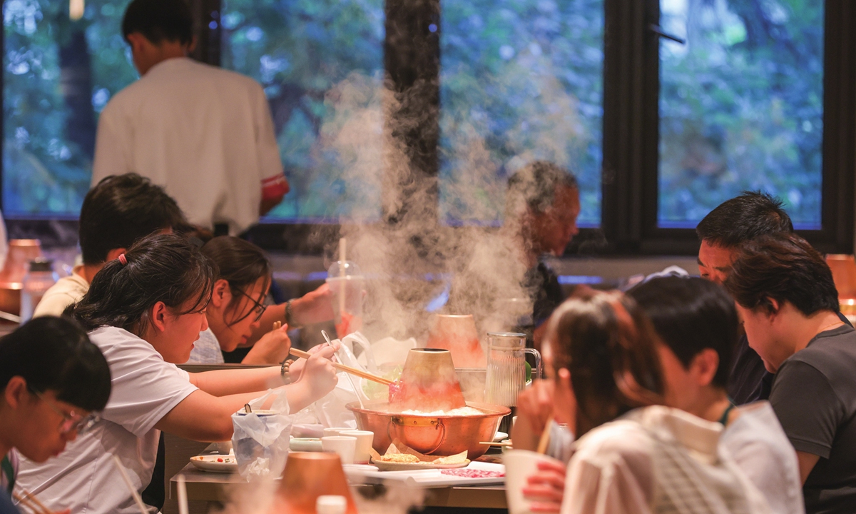 Diners enjoy hot pot at a restaurant specializing in copper pots in Beijing on August 7, 2025. 