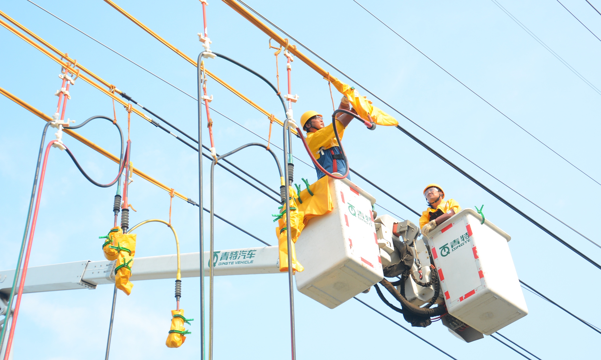 The picture shows staffers from the State Grid Binzhou Power Supply Company eliminating line fault hazards through live-line work to ensure reliable power supply for rope net enterprises.