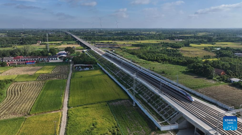 An aerial drone photo taken on Aug. 23, 2025 shows a test train running on the Xiangyang-Jingmen high-speed railway in central China's Hubei Province. The Xiangyang-Jingmen high-speed railway started test operation on Saturday. Connecting Xiangyang City of central China's Hubei Province in the north and Jingmen City of the province in the south, the 116.23-km-long railway with a designed speed of 350 kilometers per hour is an important section in one of the main passages of a greater high-speed rail artery network consisting eight vertical lines and eight horizontal lines in the country. (Photo by Chen Long/Xinhua)