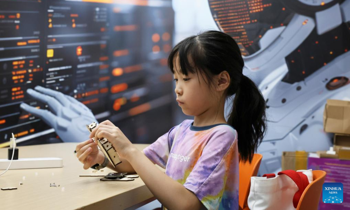 A girl assembles a remote control for toy airship at a science and technology training institution in Shanghai, east China, on Aug. 21, 2025. The summer vacation is coming to an end and children across the country have spent a wonderful holiday with diverse activities ranging from science and technology innovations to outdoor sports. (Xinhua/Fang Zhe)