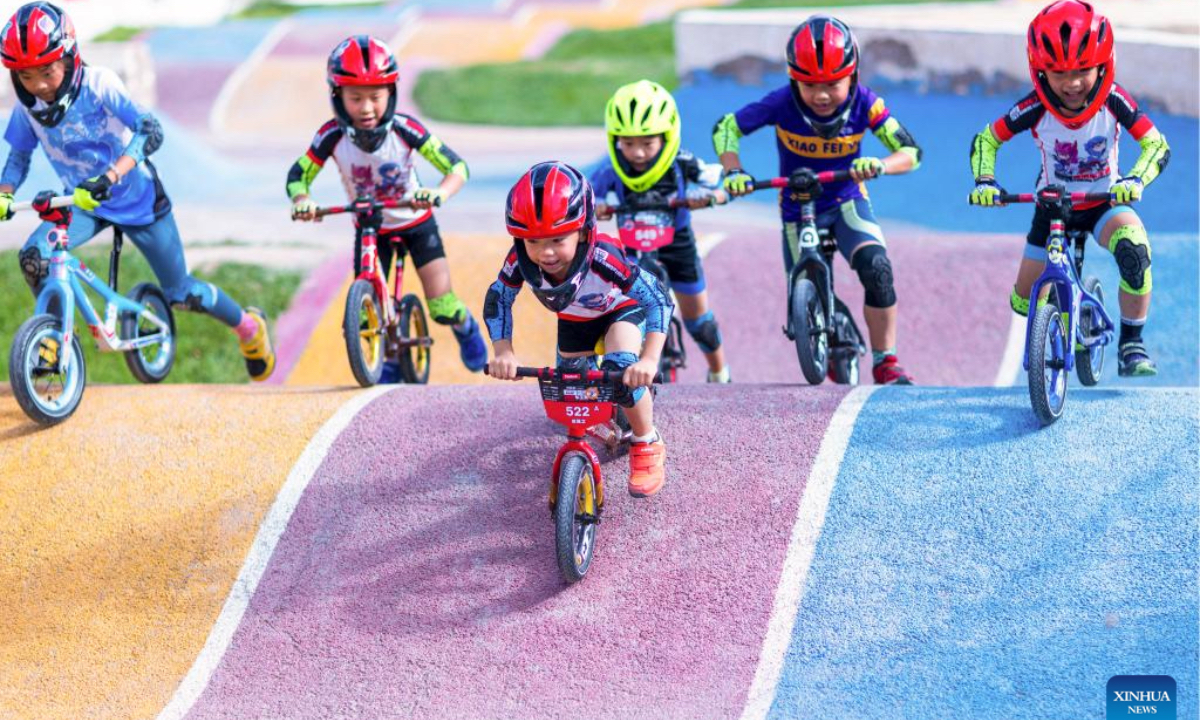 Children wearing protective gears ride bicycles in Zhangye City, northwest China's Gansu Province, on Aug. 22, 2025. The summer vacation is coming to an end and children across the country have spent a wonderful holiday with diverse activities ranging from science and technology innovations to outdoor sports. (Photo by Yang Xiao/Xinhua)