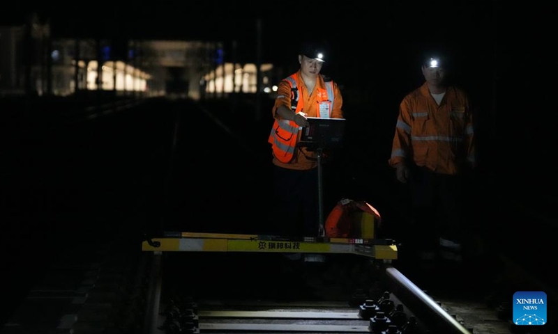 Staff members operate a track inspection instrument to examine the Hangzhou-Shaoxing-Taizhou intercity railway in east China's Zhejiang Province on early Aug. 20, 2025. Staff members inspected and maintained several systems of the railway on early Wednesday to ensure the stable operation of the Hangzhou-Shaoxing-Taizhou intercity railway.