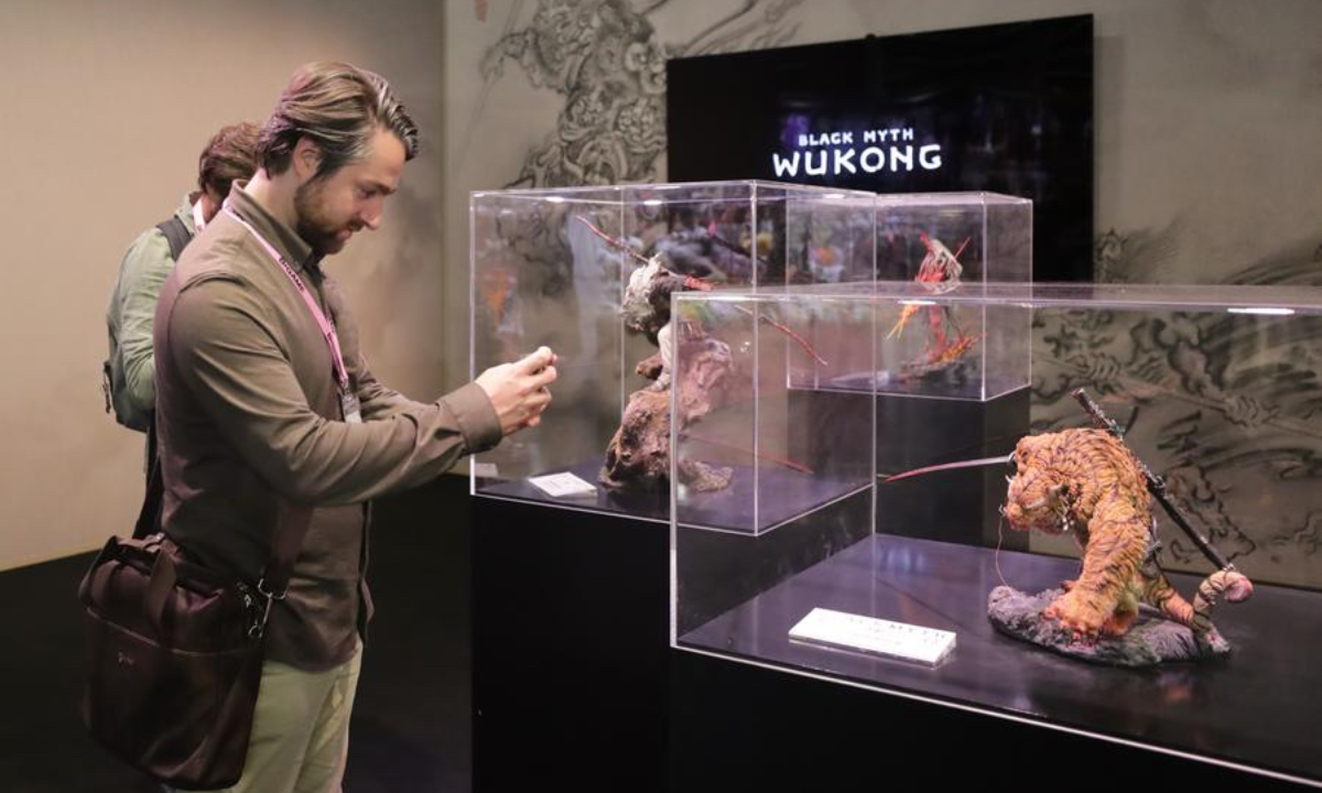 Visitors take pictures of models of game 