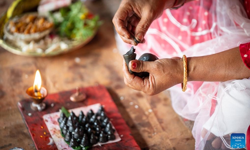 A devotee prepares a little stupa in celebration of the Gunla Festival in Lalitpur, Nepal, Aug. 21, 2025. The month-long Gunla Festival is one of the major festivals of the Newar Buddhist community, during which they recite scriptures, observe fast and visit places of worship. Photo: Xinhua