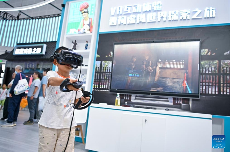 A child uses a VR device to view Jinci Temple at the 7th Shanxi Cultural Industries Fair in Taiyuan, north China's Shanxi Province, Aug. 21, 2025. The fair kicked off here on Thursday and will last till Aug. 25, attracting about 2,000 exhibitors from over 30 countries and regions worldwide. Photo: Xinhua