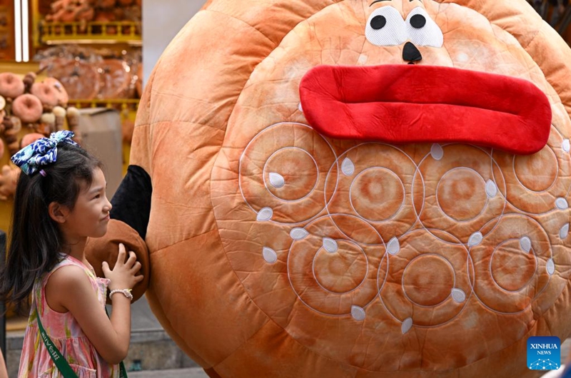 A girl has fun at the Grand Bazaar in Urumqi, northwest China's Xinjiang Uygur Autonomous Region, Aug. 21, 2025. Scenic areas across China have entered peak season for tourism. The Grand Bazaar receives an average of more than 200,000 daily tourists since July this year. Photo: Xinhua