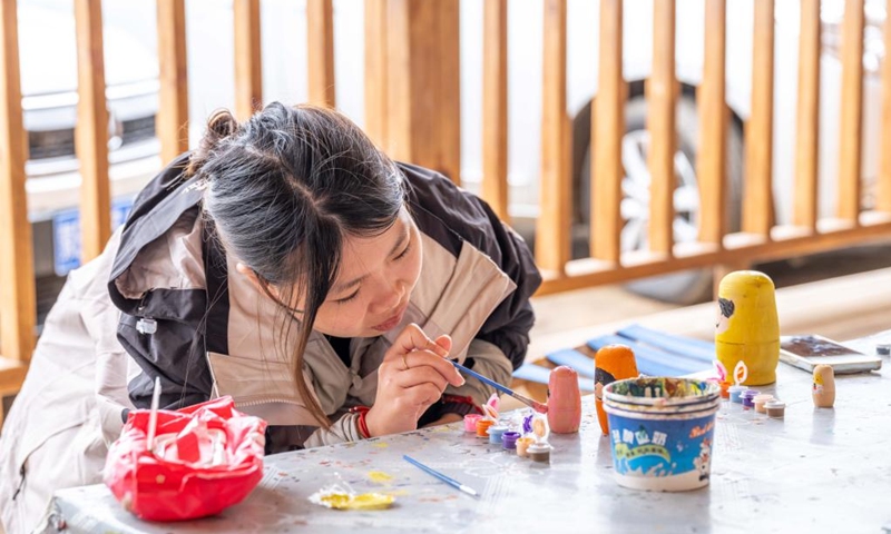 A tourist experiences painting on Matryoshka dolls at Enhe Township of Hulun Buir, north China's Inner Mongolia Autonomous Region, on Aug. 21, 2025. Enhe, located in the northeastern corner of Inner Mongolia, is China's only Russian ethnic township that has for years drawn travelers seeking its inspiring blend of Chinese-Russian culture, hearty cuisine and sweeping natural vistas.

In recent years Enhe has attracted many tourists by promoting unique activities such as local family visiting, Russian bread making and Matryoshka doll painting.

The township, with a population of only about 2,900, received 615,000 visitors in 2024, who had brought in a gross tourism revenue of 92.25 million yuan (about 12.85 million U.S. dollars).  Photo: Xinhua