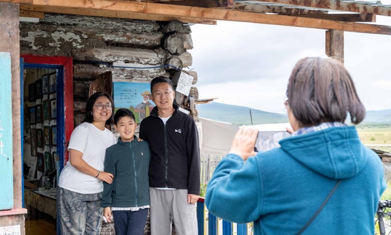 Tourists take photos in front of a distinctive Russian-style wooden house at Enhe Township of Hulun Buir, north China's Inner Mongolia Autonomous Region, on Aug. 21, 2025. Enhe, located in the northeastern corner of Inner Mongolia, is China's only Russian ethnic township that has for years drawn travelers seeking its inspiring blend of Chinese-Russian culture, hearty cuisine and sweeping natural vistas.

In recent years Enhe has attracted many tourists by promoting unique activities such as local family visiting, Russian bread making and Matryoshka doll painting.

The township, with a population of only about 2,900, received 615,000 visitors in 2024, who had brought in a gross tourism revenue of 92.25 million yuan (about 12.85 million U.S. dollars). Photo: Xinhua