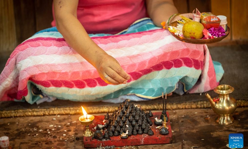 A devotee worships little stupas with offerings in celebration of the Gunla Festival in Lalitpur, Nepal, Aug. 21, 2025. The month-long Gunla Festival is one of the major festivals of the Newar Buddhist community, during which they recite scriptures, observe fast and visit places of worship. Photo: Xinhua