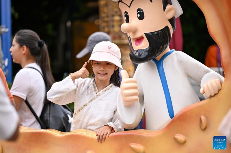 A girl poses for photos at the Grand Bazaar in Urumqi, northwest China's Xinjiang Uygur Autonomous Region, Aug. 21, 2025. Scenic areas across China have entered peak season for tourism. The Grand Bazaar receives an average of more than 200,000 daily tourists since July this year. Photo: Xinhua