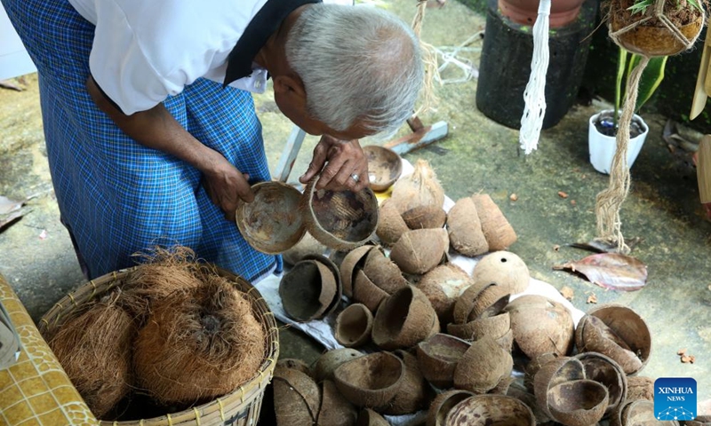 An artisan selects coconut shells to make handicrafts at a workshop in Yangon, Myanmar, Aug. 19, 2025. (Xinhua/Myo Kyaw Soe)